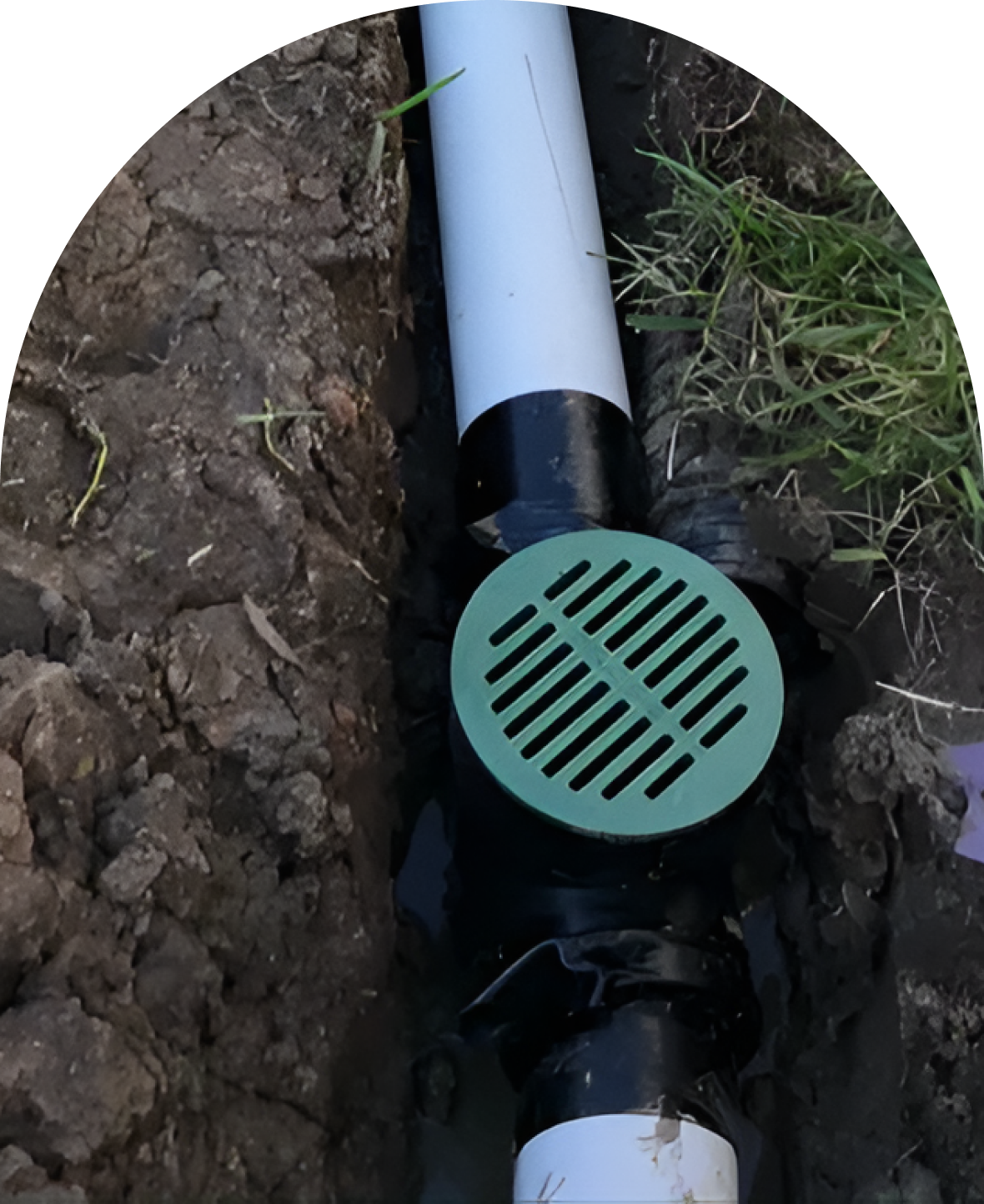 Buried drainage pipe with green grate cover