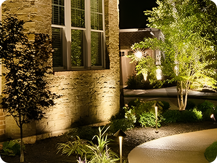 Nighttime garden with illuminated stone wall